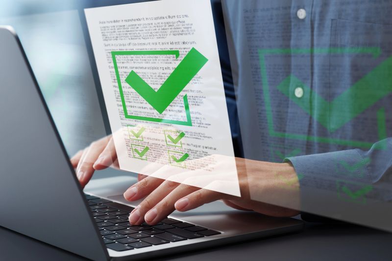 Preparation of documents. Documents and checkmark. Compliance and documentation. Hands typing on laptop computer keyboard. Businessman working at desk in office.