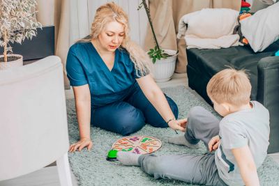Woman and child playing a board game on the floor.