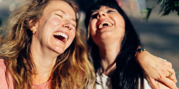 Two women laughing joyfully together.