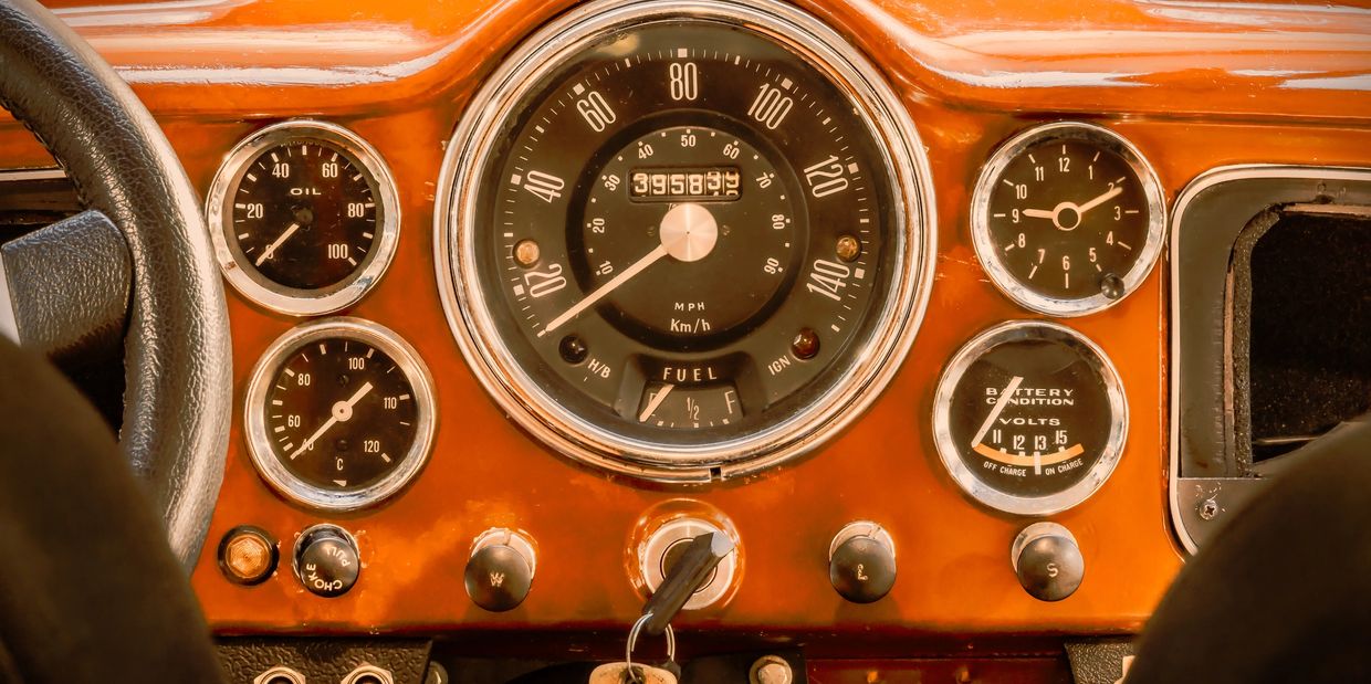the dashboard of a classic collector car, displaying gauges and the speedometer