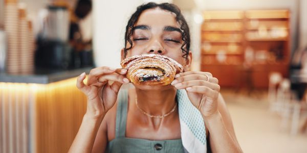 Woman enjoying a pastry at a cafe.