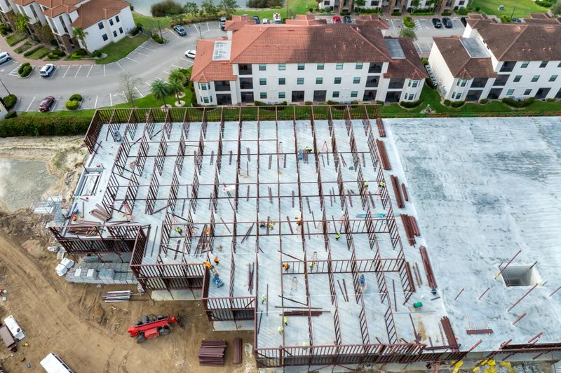 Industrial construction site with workers assembling metal frame building. Development of residential housing in America. Real estate market in the USA.