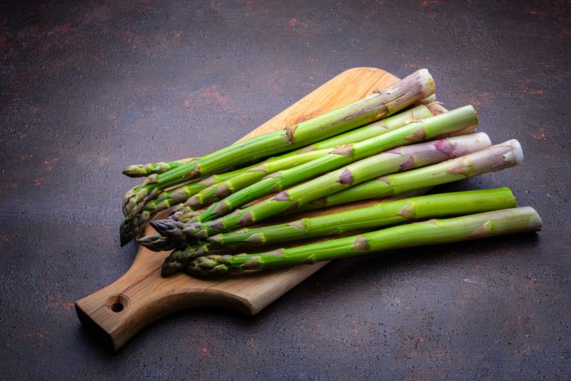 Fresh organic asparagus on wooden cutting board. High resolution 42Mp studio digital capture taken with Sony A7rII and Sony FE 90mm f2.8 macro G OSS lens