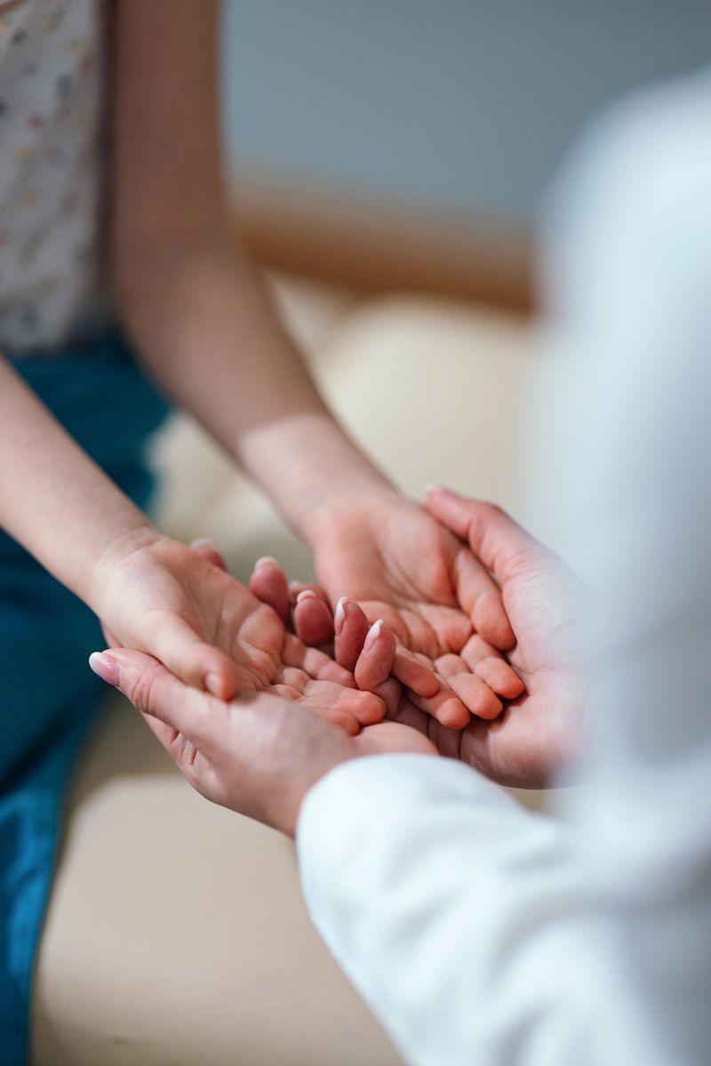 An intimate scene depicting a doctor holding the hands of a child, emphasizing care and trust in a medical setting. The moment symbolizes compassion and professional support during a consultation.