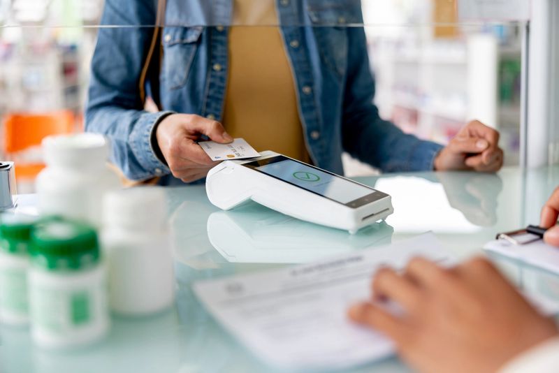 Close-up on a customer making a contactless payment at the pharmacy - shopping concepts