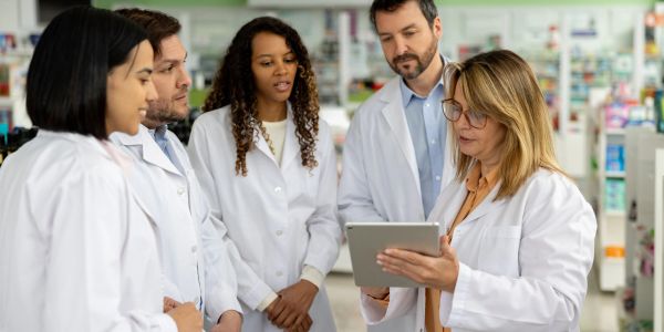 Scientists discussing data on a tablet in a lab.