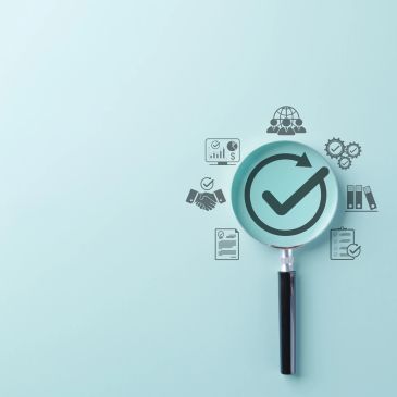 Magnifying glass focusing on a checkmark with business icons.