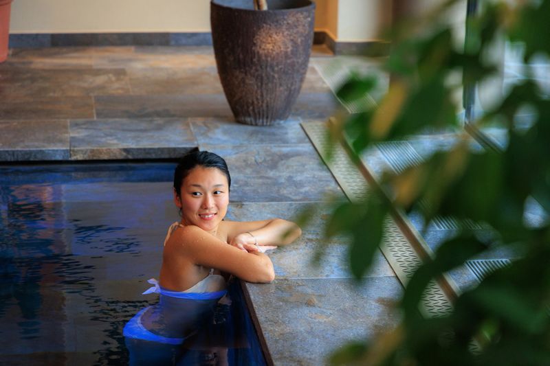 Young woman enjoying indoor pool hot water spa