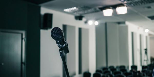 A microphone on a stand in an empty conference room.