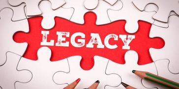 Puzzle pieces surrounding a red piece with the word 'LEGACY' and colored pencils.
