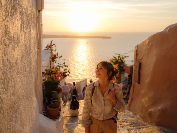 A couple planning a trip with a travel agent amidst iconic landmarks and travel elements.