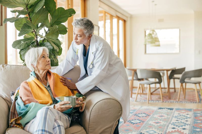 A home healthcare professional providing comfort and support to a happy senior lady.
