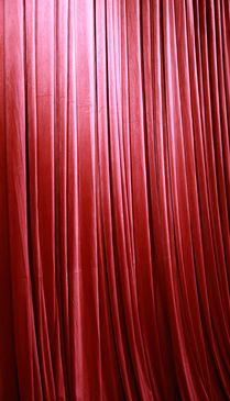 Rich red stage curtains with elegant folds.