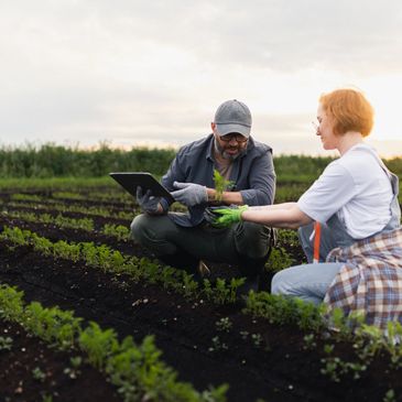 profesor con un tablet en la mano imparte consejos a productora en el mismo campo