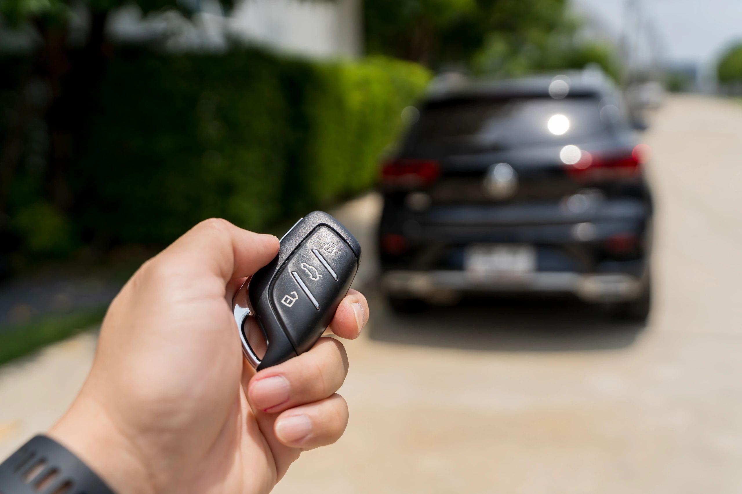 Driver pressing a key fob to remote start an SUV