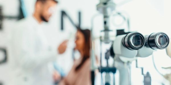 Optometry exam setup with blurred doctor and patient.