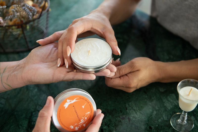 Woman's hands holding a scented soy candle in an aromatherapy store - Handmade soy candles made with essential oils of scented flowers  - Buenos Aires - Argentina