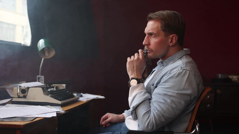 Smoke-filled vintage office with writer at work, cinematic soft lighting highlighting typewriter and papers.