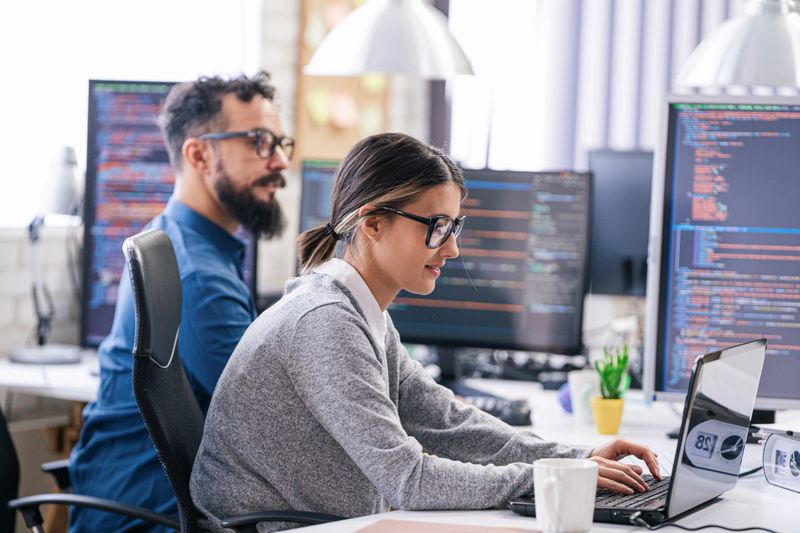 Software programmers analyzing html code and database, brainstorming script ideas to develop new security system. Engineers working with coding language collaborating on group project