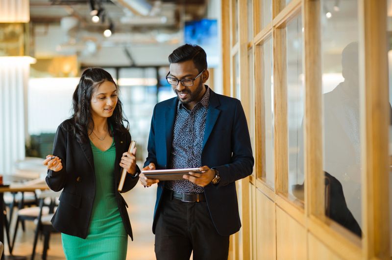 Two Businesspeople Reviewing Data on a Tablet