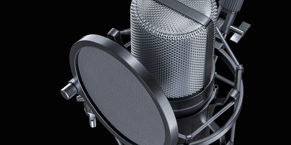 Close-up of a professional studio microphone with pop filter on black background.