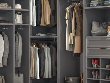Neatly organized modern wardrobe with jackets, shoes, and handbags.