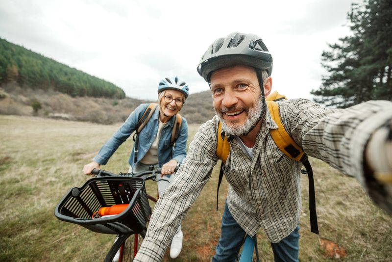 Cheerful mature couple taking a selfie while resting from their bicycle ride