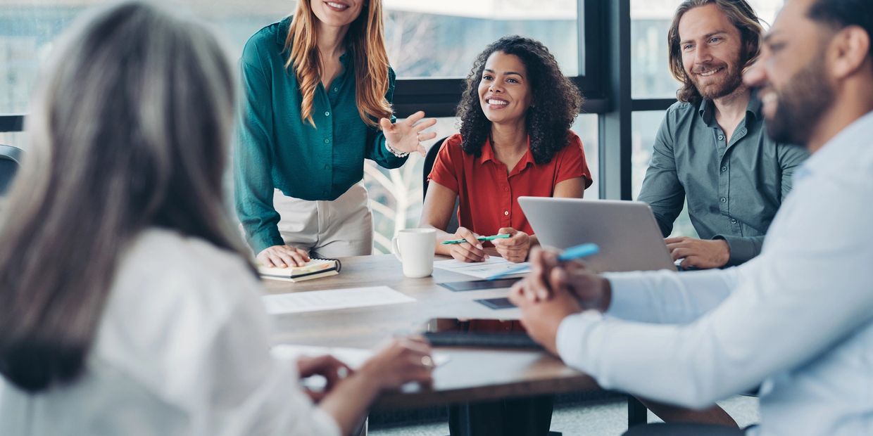 A diverse group collaborating happily in a modern office meeting.