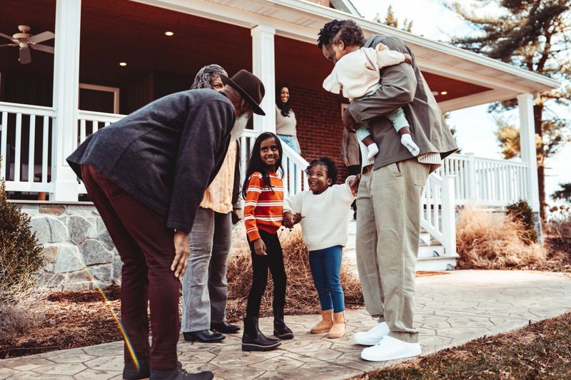 A multiracial multi-generation family warmly greets each other outside a farmhouse in rural Maryland for a fun and relaxing weekend gathering.