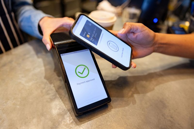 Close-up on a customer making a mobile payment at a cafe - financial technology concepts