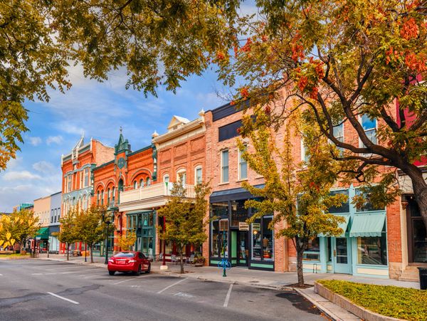Charming historic downtown street with colorful brick buildings and autumn trees.