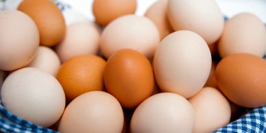 A mix of brown and white eggs in a basket.