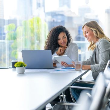 Two women collaborating in a bright office.