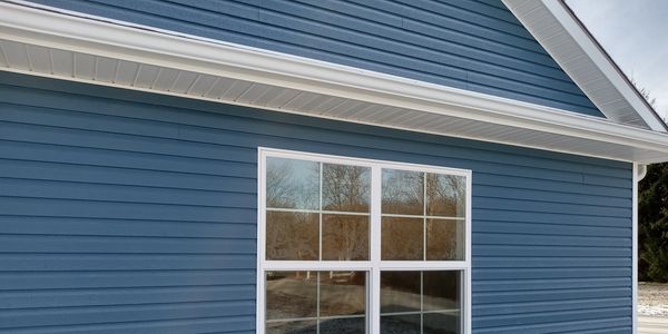 brand new blue vinyl siding with white trim on a home