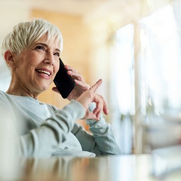 Smiling senior woman having a phone conversation at home.