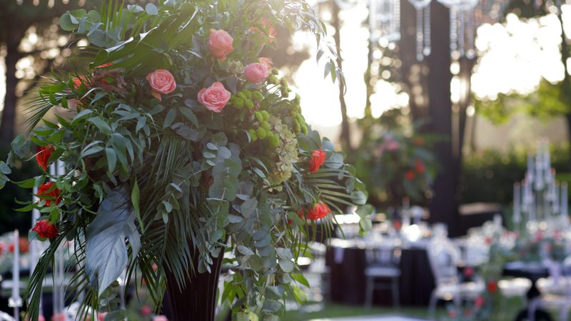 Beautiful floral arrangements used as table decorations at a wedding ceremony. The image captures the romantic and festive atmosphere of a wedding, featuring carefully arranged flowers that add elegance and charm to the celebration. Perfect for themes related to weddings, event planning, floral design, and special occasions.