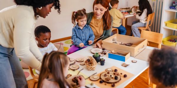 Children and teachers engaged in a creative classroom activity.