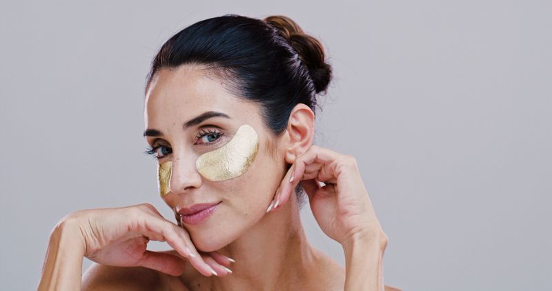 Skincare, woman and eye patches in studio for puffiness reduction, collagen treatment and hyaluronic acid. Mockup, mature person and portrait with beauty product for dark circles on white background