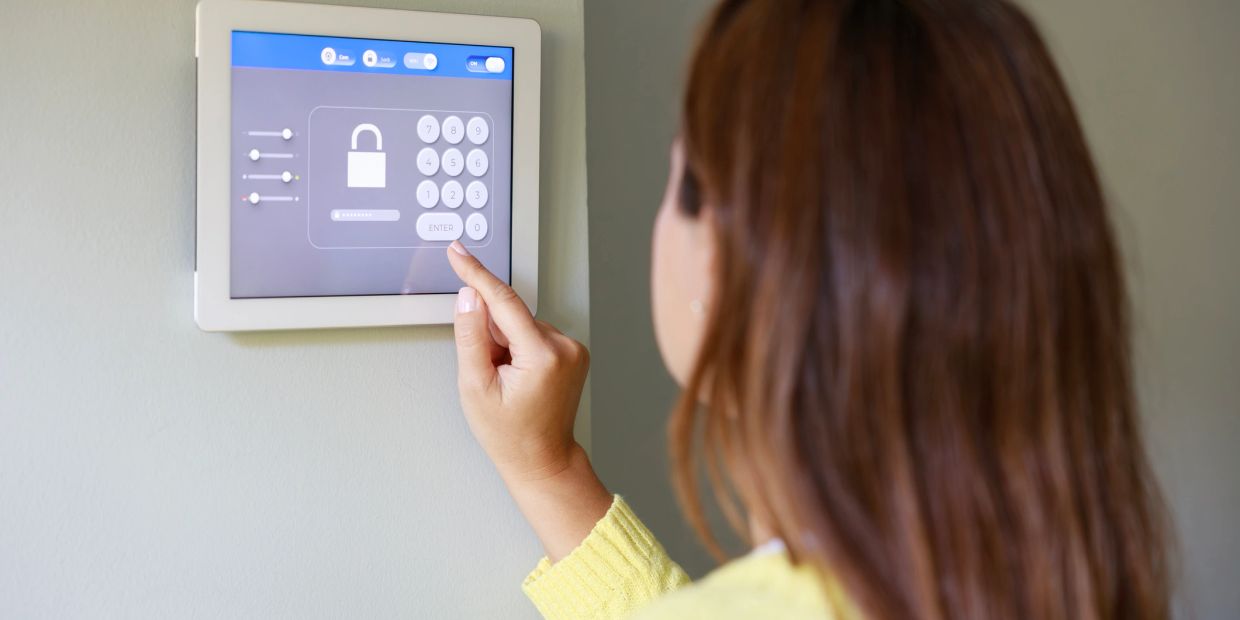 Woman entering code on a security keypad.