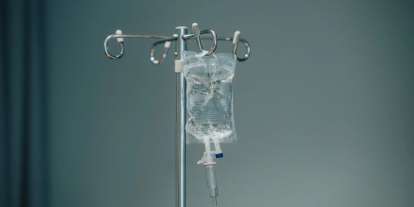 IV drip bag hanging on a metal stand in a hospital.