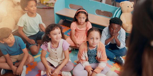 Group of children sitting on a colorful play mat.