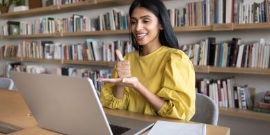 Woman using laptop in library.