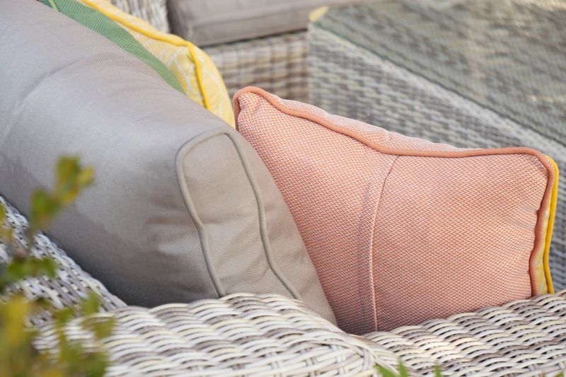 Cushions are arranged on a stylish outdoor sofa set for comfort during summer gatherings