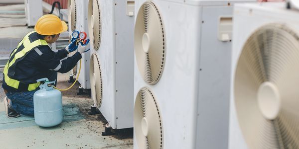 Technician is checking gas pressure in central ac and charging gas