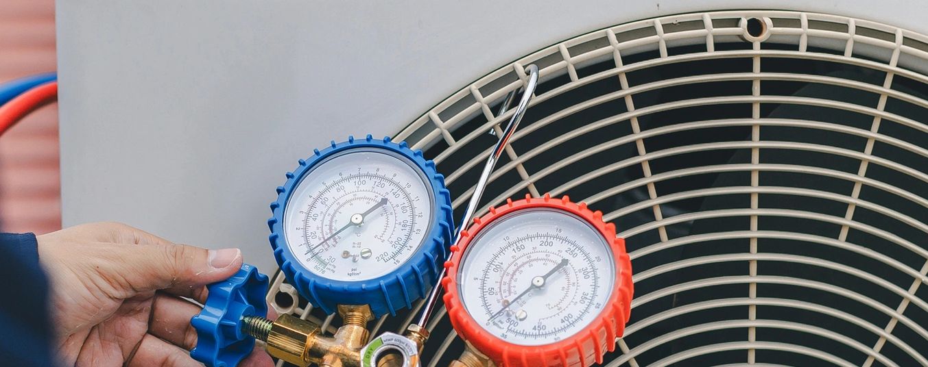 Person adjusting HVAC pressure gauges.