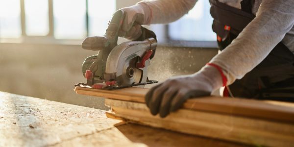 Person cutting wood with a circular saw.