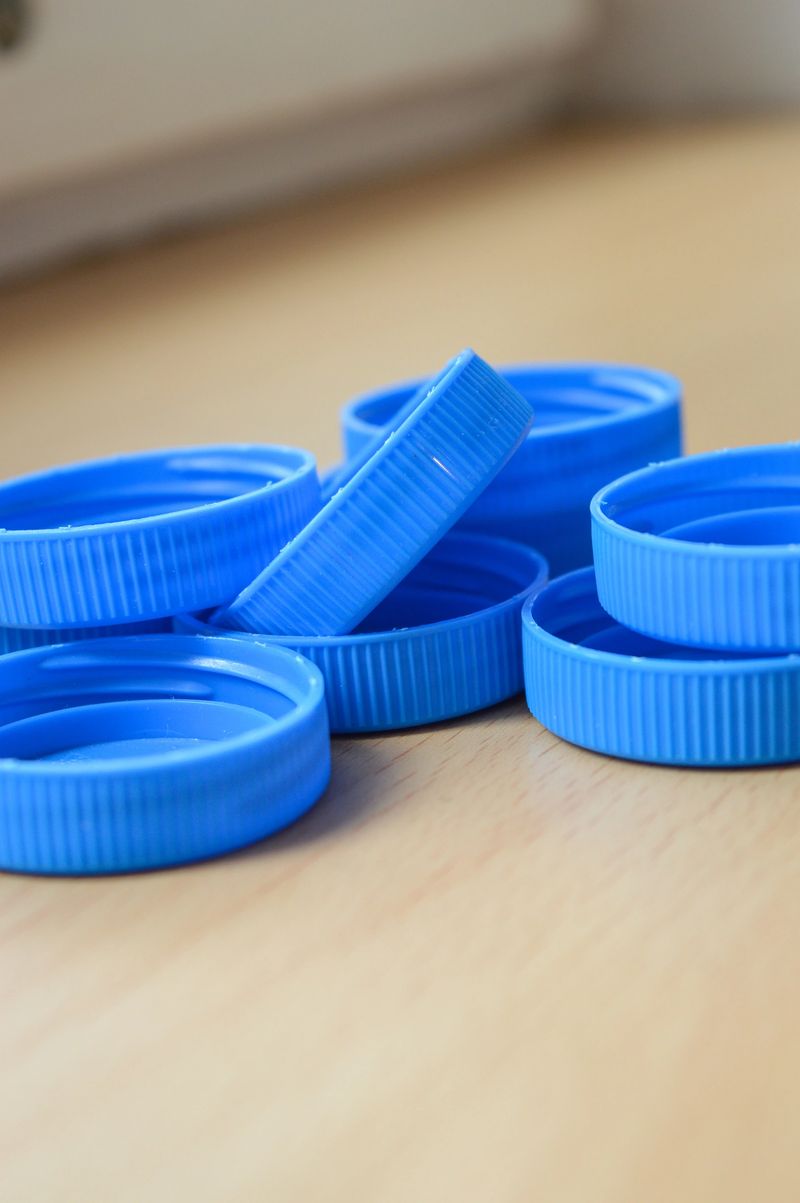 close-up view of many blue plastic bottle caps collected in a white plastic bag recycling and waste sorting awareness plastic reuse upcycling diy ideas eco-friendly visuals packaging industry