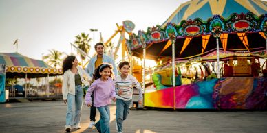 Familia feliz en un parque de diversiones al atardecer.
