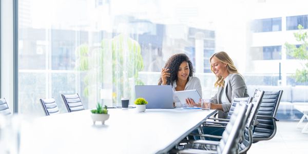 Two women collaborating in a bright office.