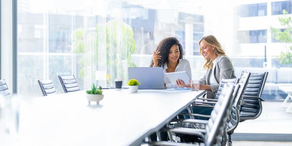 Are two women sitting on the chair and looking on Laptop screen
